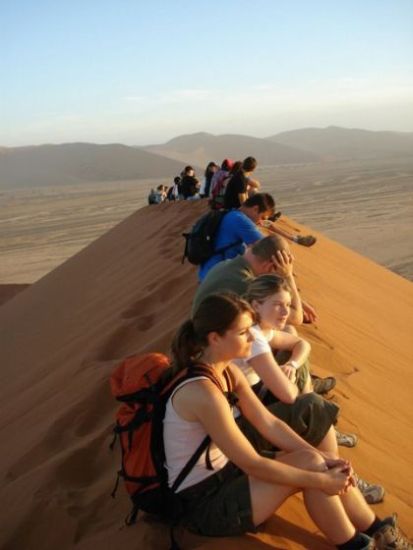 Overlanders dune climbing in Sossusvlei, Namibia